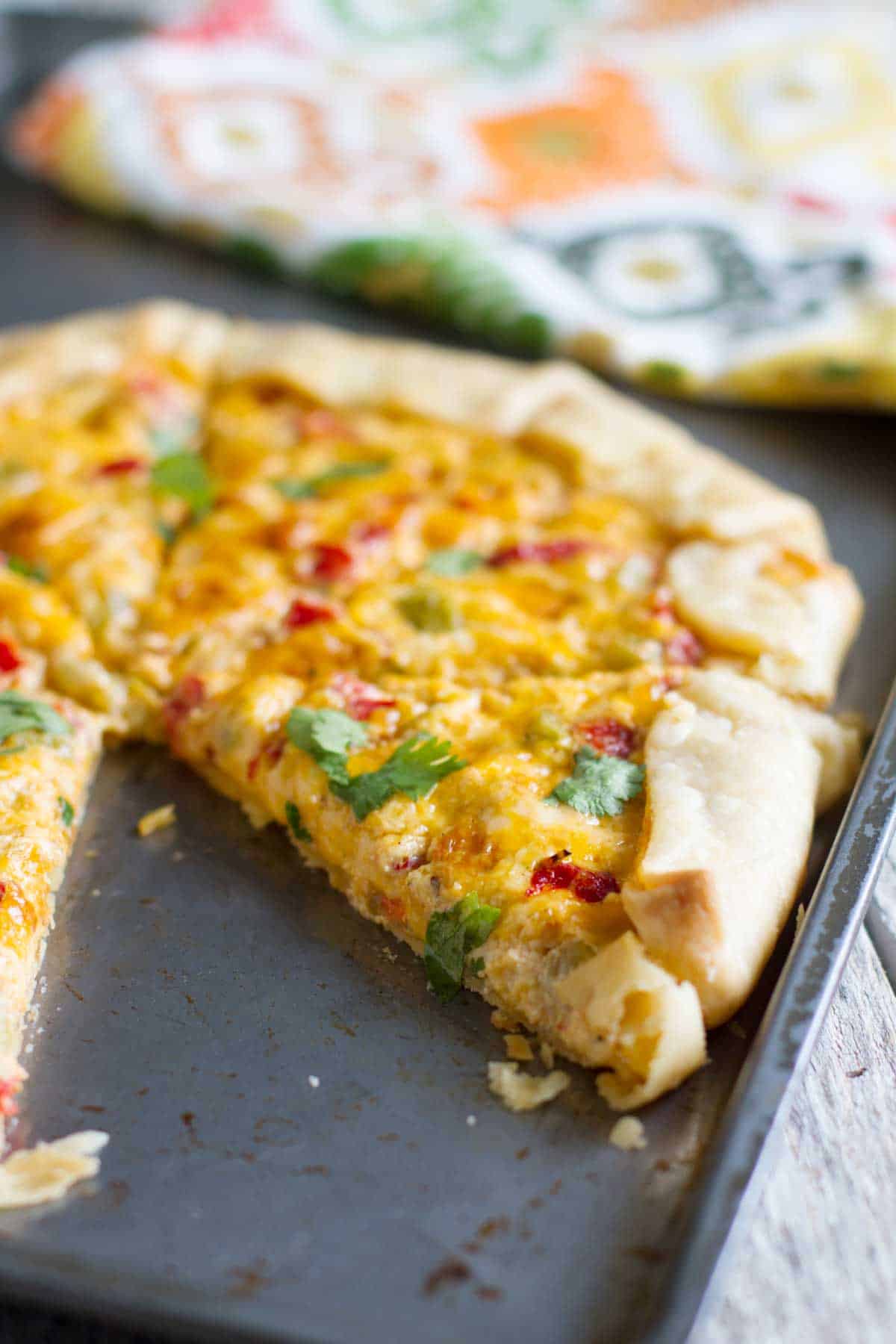 Tex-Mex Appetizer Tart on a baking sheet with a few slices gone.