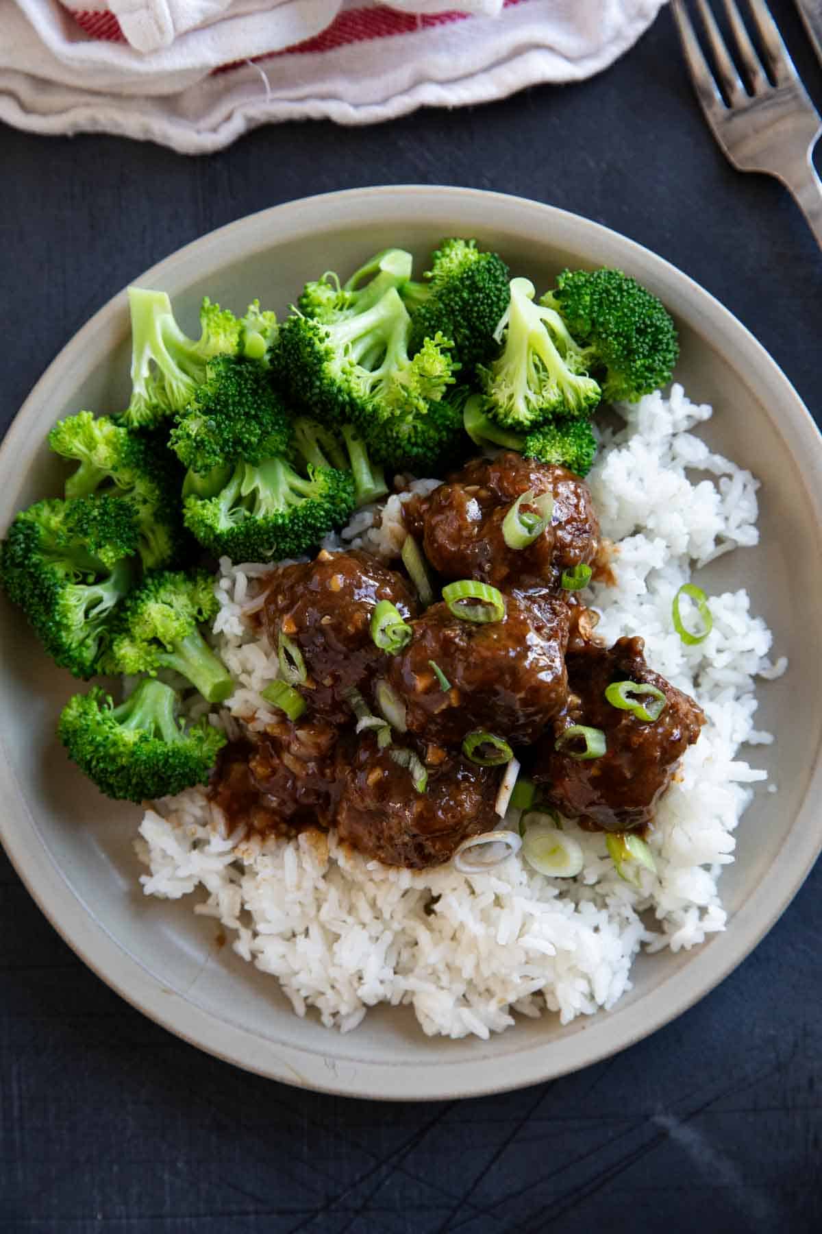 Stack of Asian Meatballs served over rice.