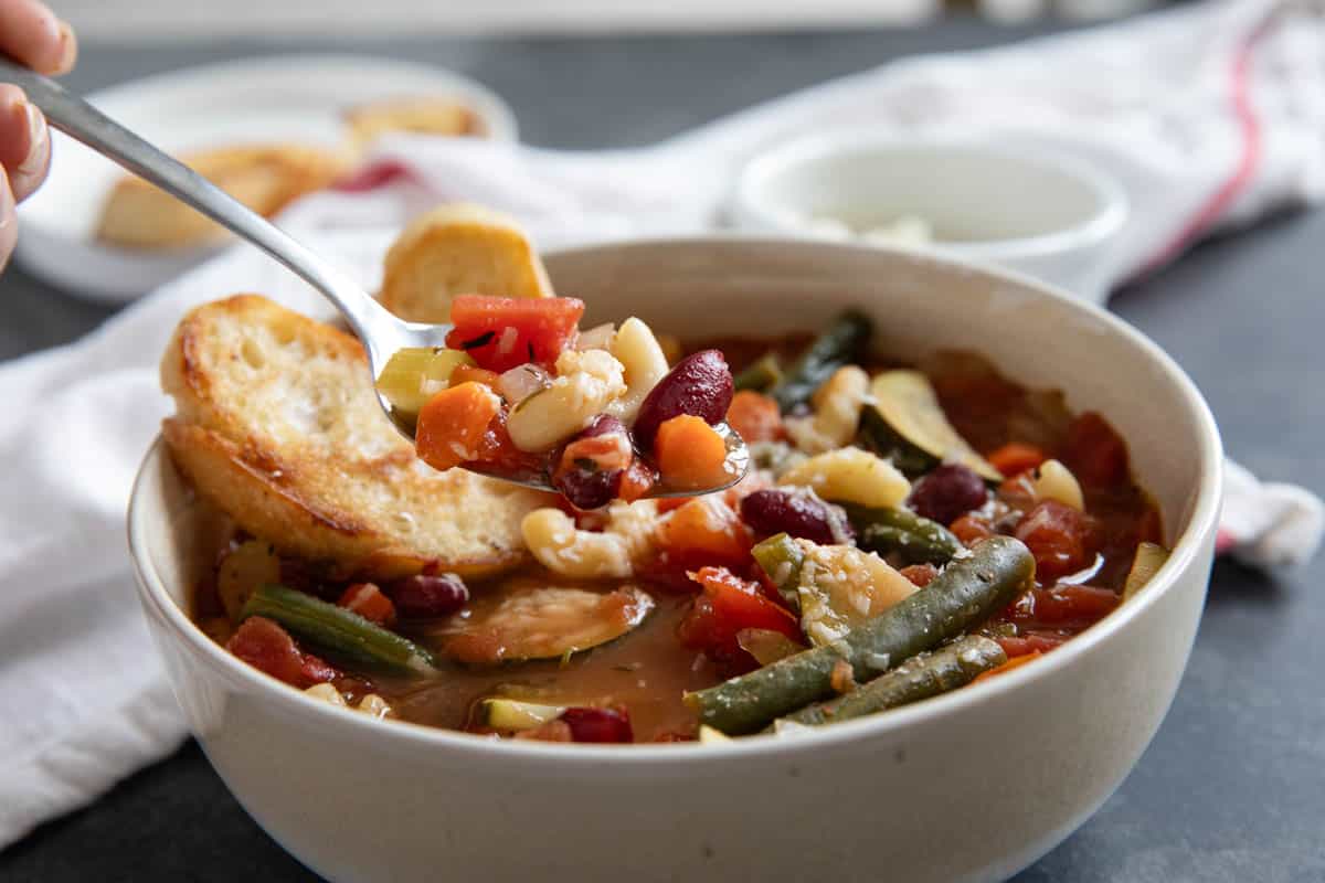 Spoonful of minestrone soup with beans and pasta.