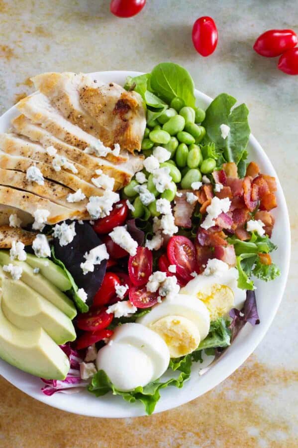 Cobb salad with grilled chicken, tomatoes, eggs, edamame, bacon, and avocado.