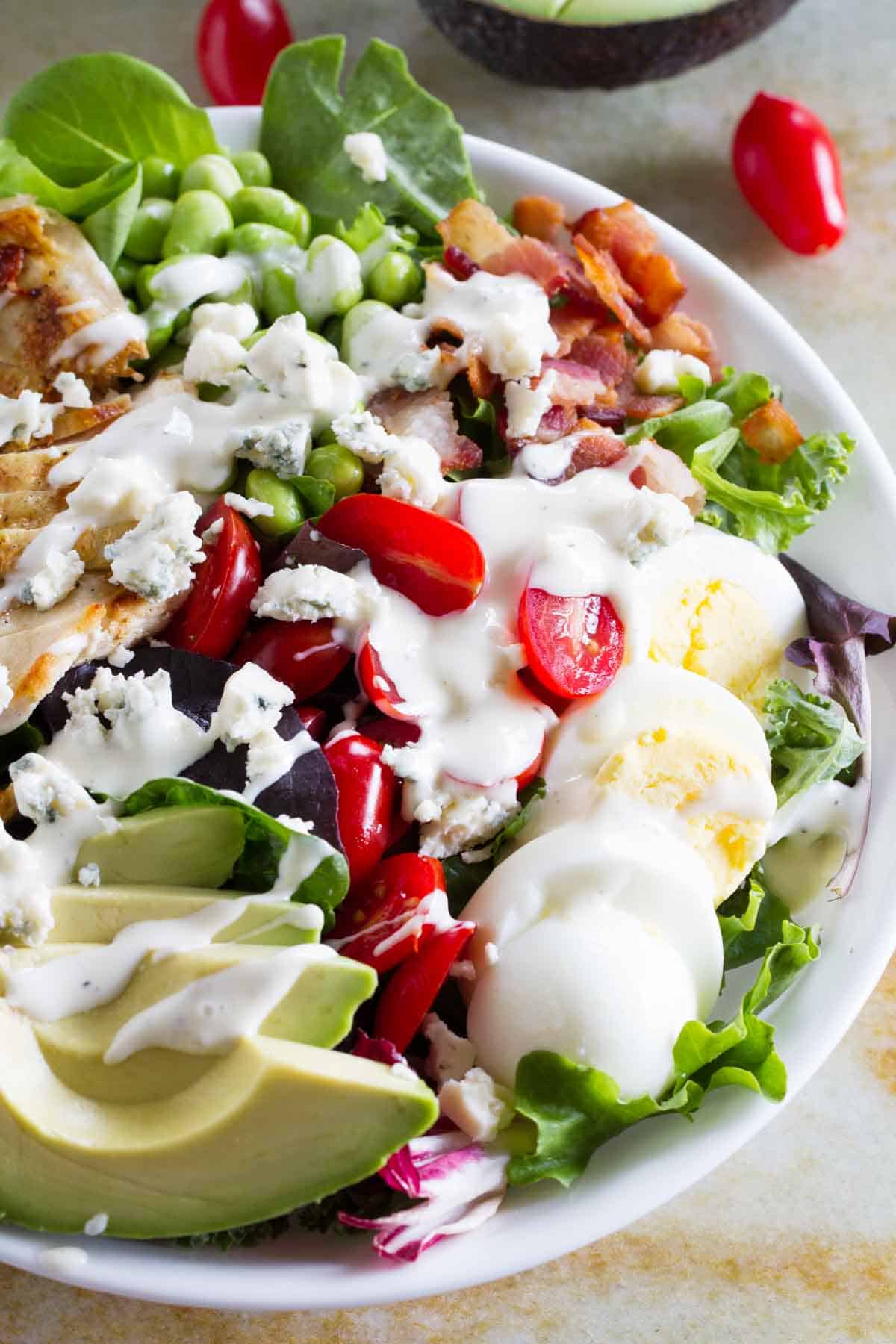 Protein packed cobb salad with blue cheese and ranch dressing on top.