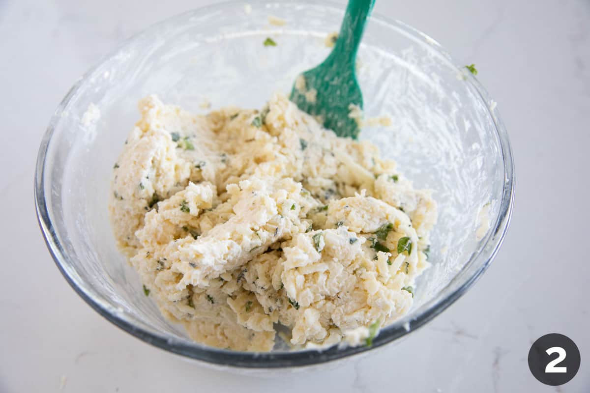 Mixing ingredients together to make white cheese dip.