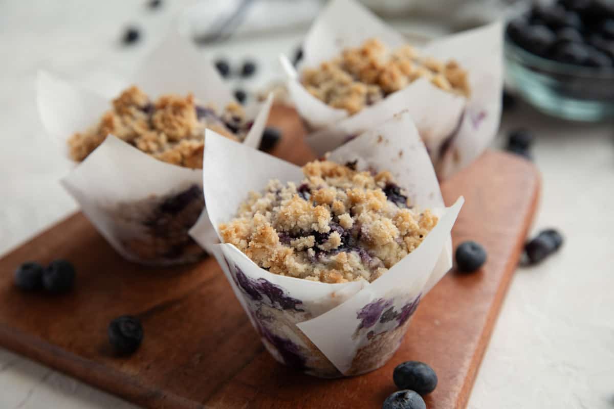 3 Blueberry muffins topped with streusel and extra blueberries.