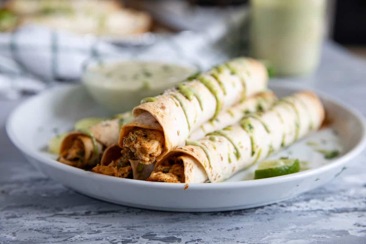 Chicken Flautas on a plate, drizzled with cilantro ranch.