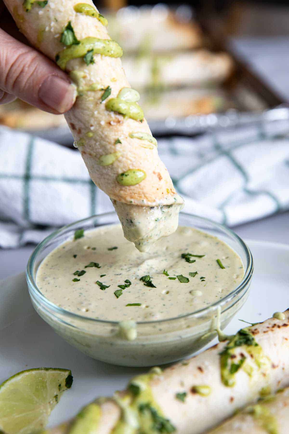 Dipping a chicken flauta into cilantro ranch sauce.