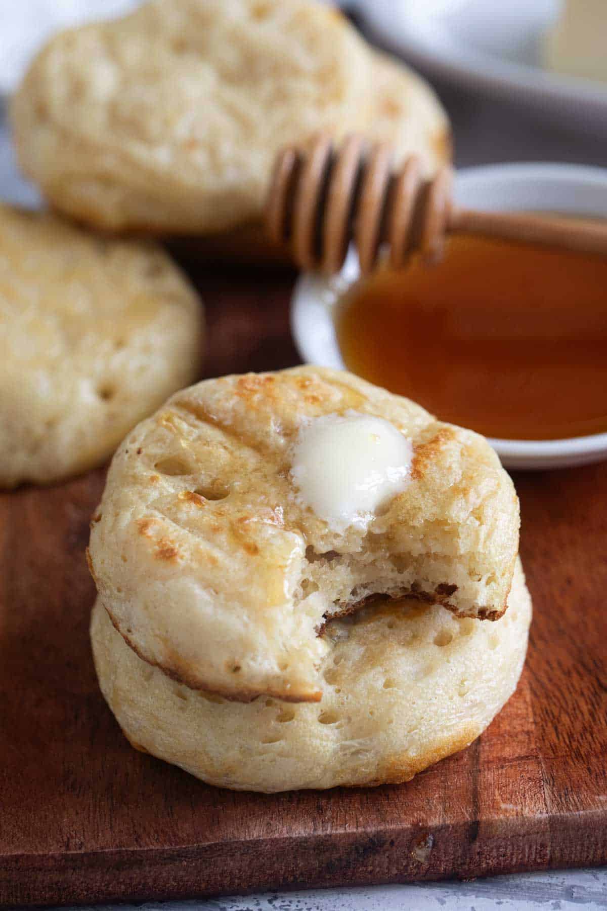 Crumpets stacked on each other with a pat of butter on top.