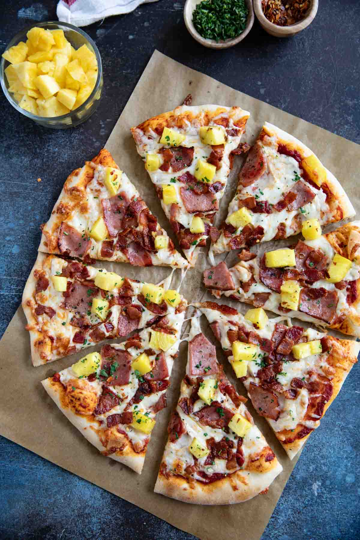 Full Hawaiian pizza cut into slices.