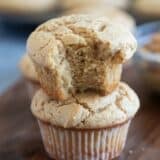 Two peanut butter muffins stacked, with a bite taken from the top muffin.