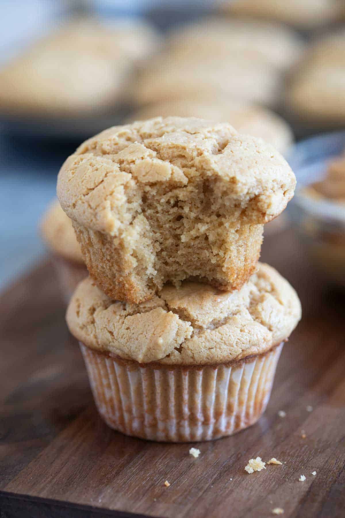Two peanut butter muffins stacked, with a bite taken from the top muffin.
