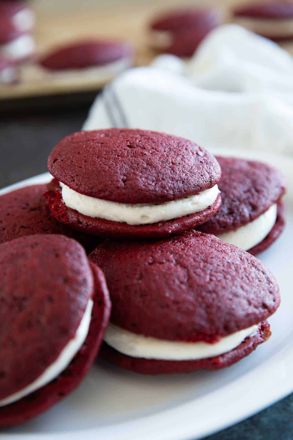 Red Velvet Whoopie Pies stacked on a plate.