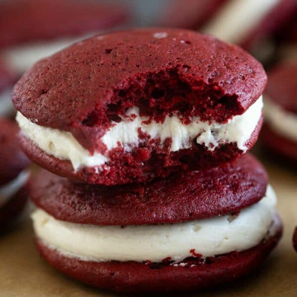 Two red velvet whoopie pies stacked on top of each other.