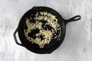 Onion and garlic cooking in a skillet.