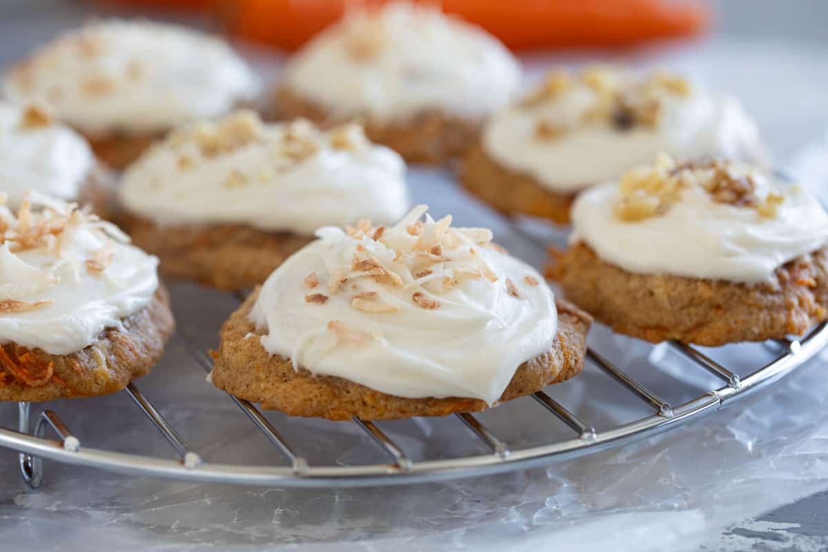 Carrot Cake Cookies frosted with cream cheese on a cooling rack.