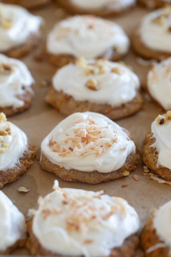 Carrot Cake Cookies topped with coconut and walnuts on a baking sheet.