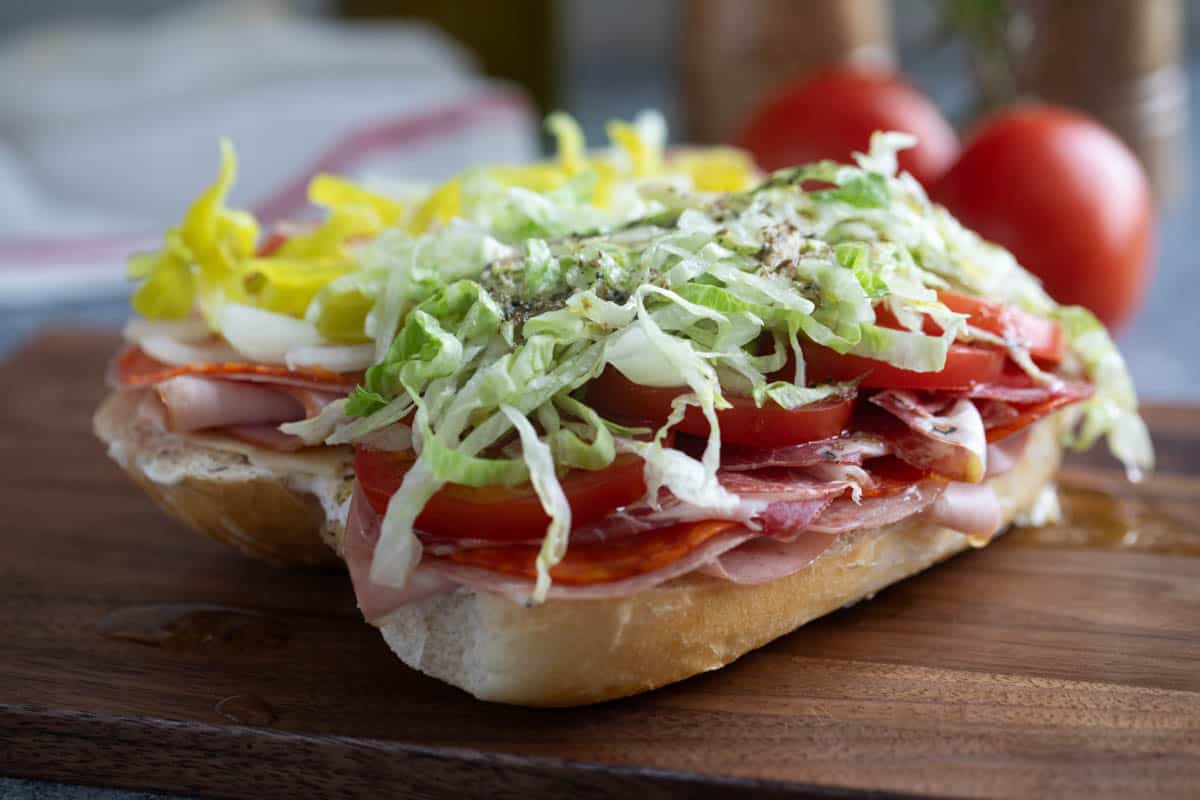 Open Italian sub topped with vegetables.