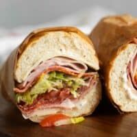 Italian Sub cut in half with the meat, cheese, and vegetables showing.