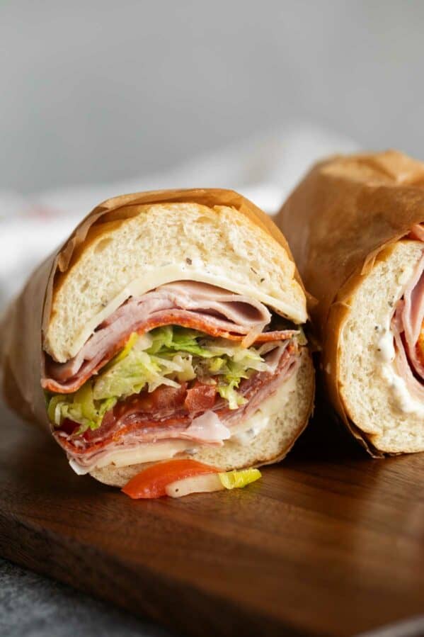 Italian Sub cut in half with the meat, cheese, and vegetables showing.