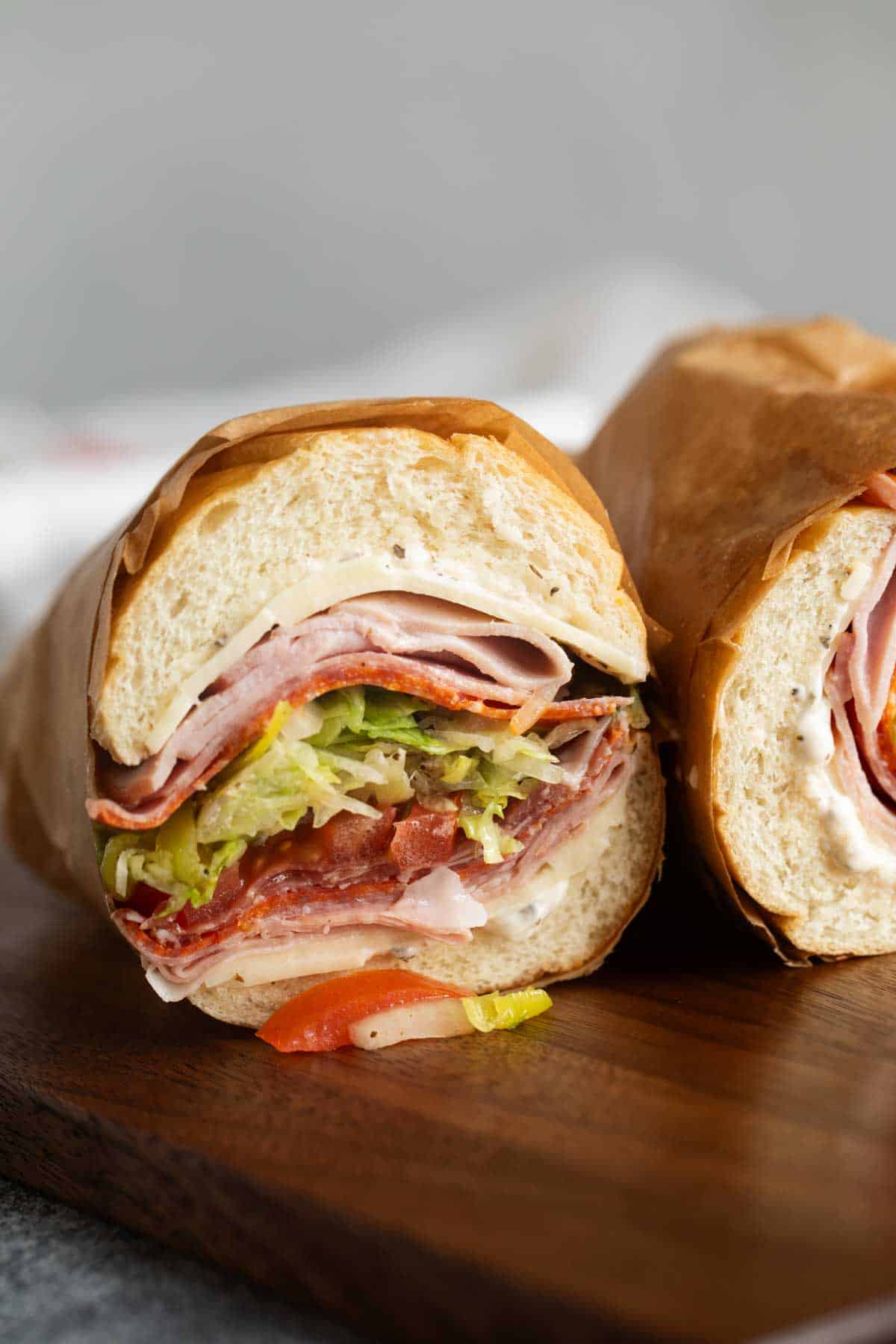 Italian Sub cut in half with the meat, cheese, and vegetables showing.