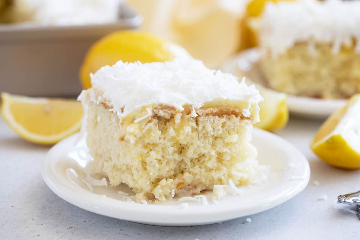 Slice of Lemon Poke Cake topped with coconut.