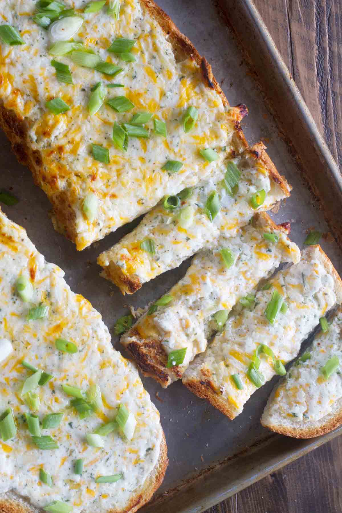 Ranch Cheese Bread topped with green onions, cut into slices.