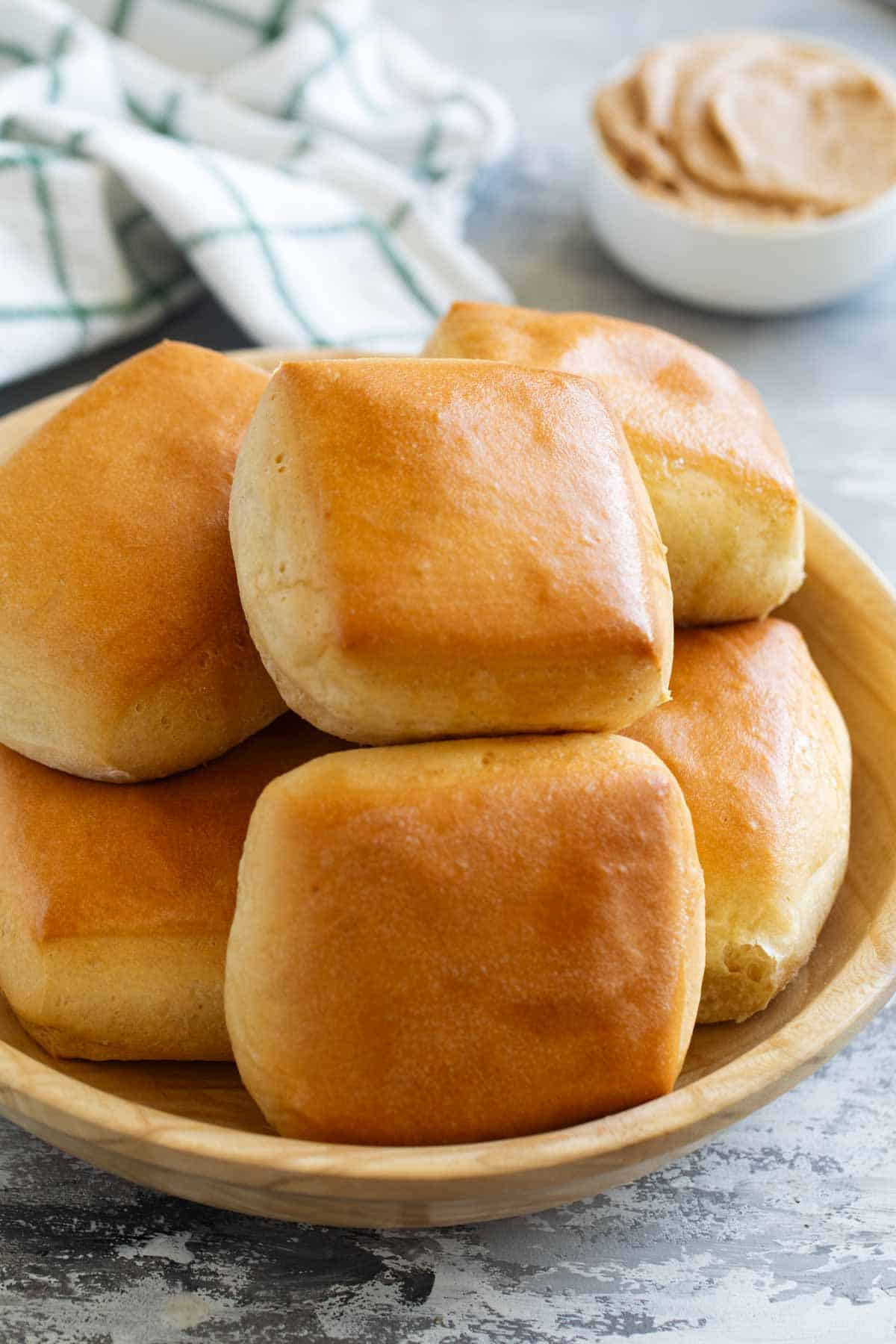 Texas Roadhouse Rolls stacked in a wooden bowl.