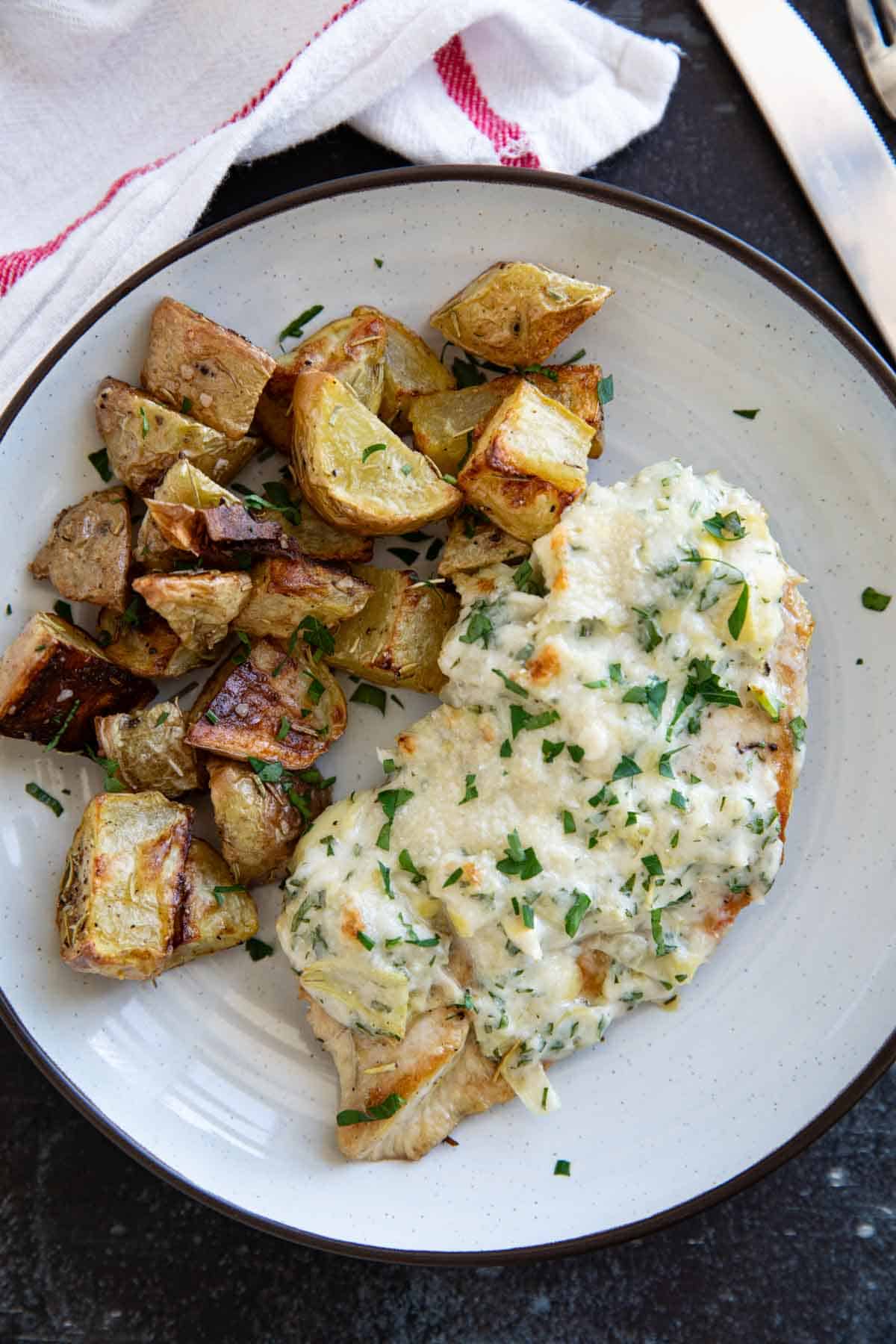 Chicken breast topped with creamy artichoke topping and served with roasted potatoes.