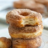 Three biscuit donuts stacked on top of each other, covered in cinnamon sugar.