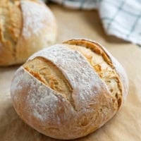 Two loaves of artisan bread on parchment paper.
