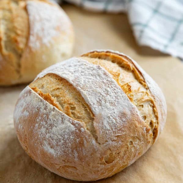 Two loaves of artisan bread on parchment paper.