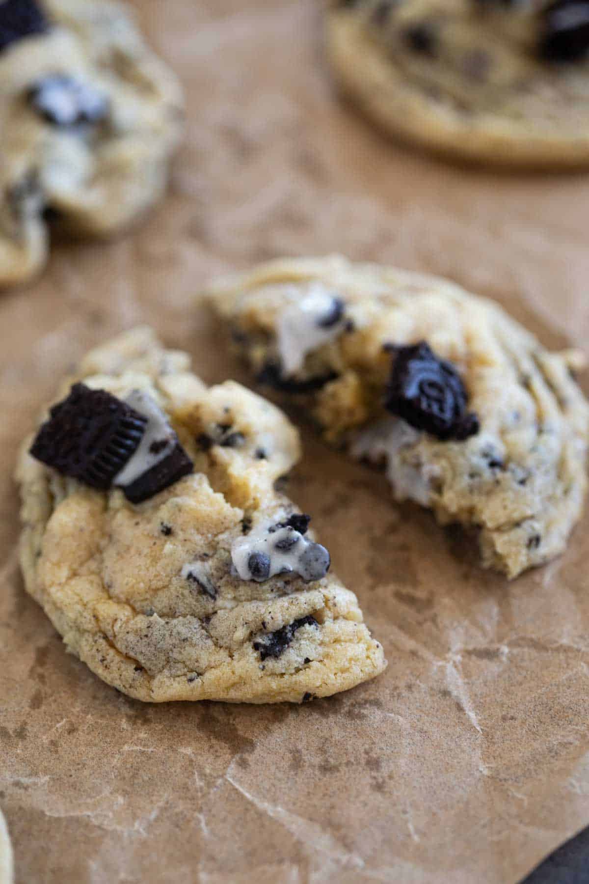 Cookies and Cream Cookie broken in half on parchment.