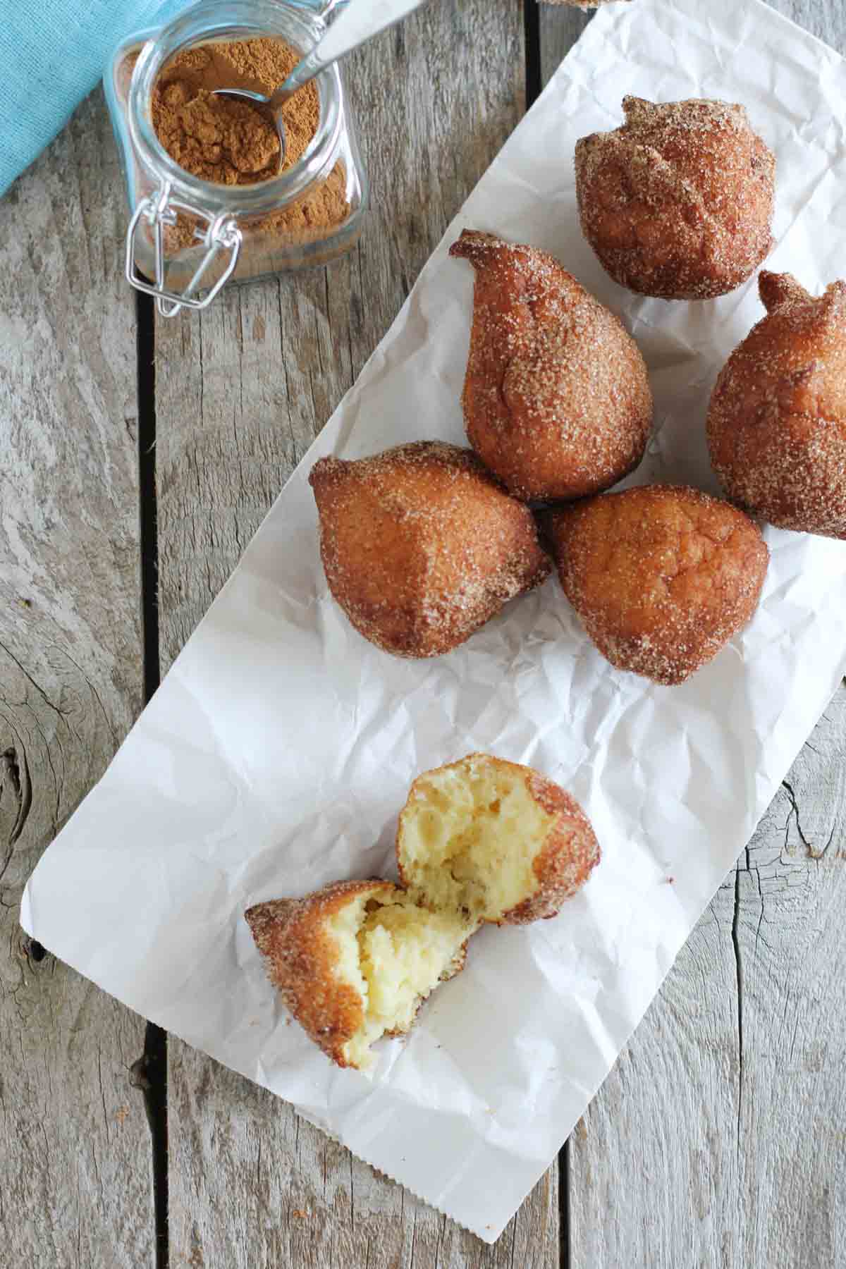 Cinnamon sugar ricotta doughnuts with one torn in half to show interior texture.