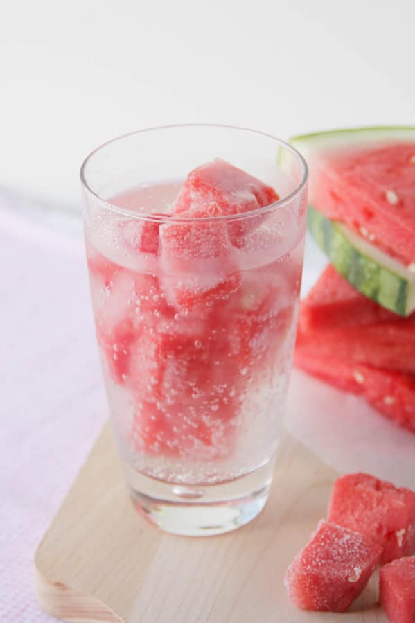 Glass filled with watermelon ice and sparkling water.