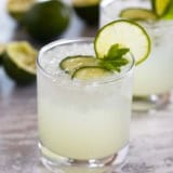 Glass of cucumber limeade with a lime slice on the glass.