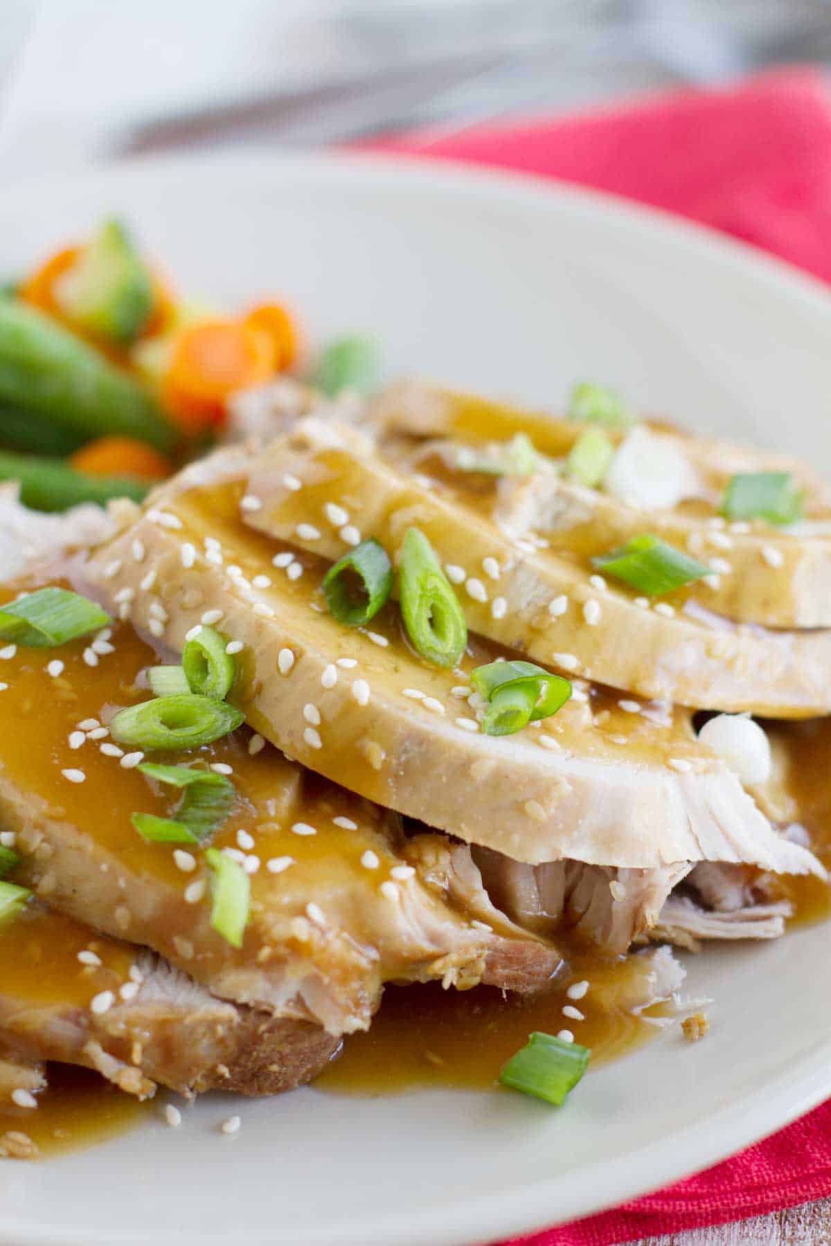 Slow cooker sesame pork sliced and served on a plate.