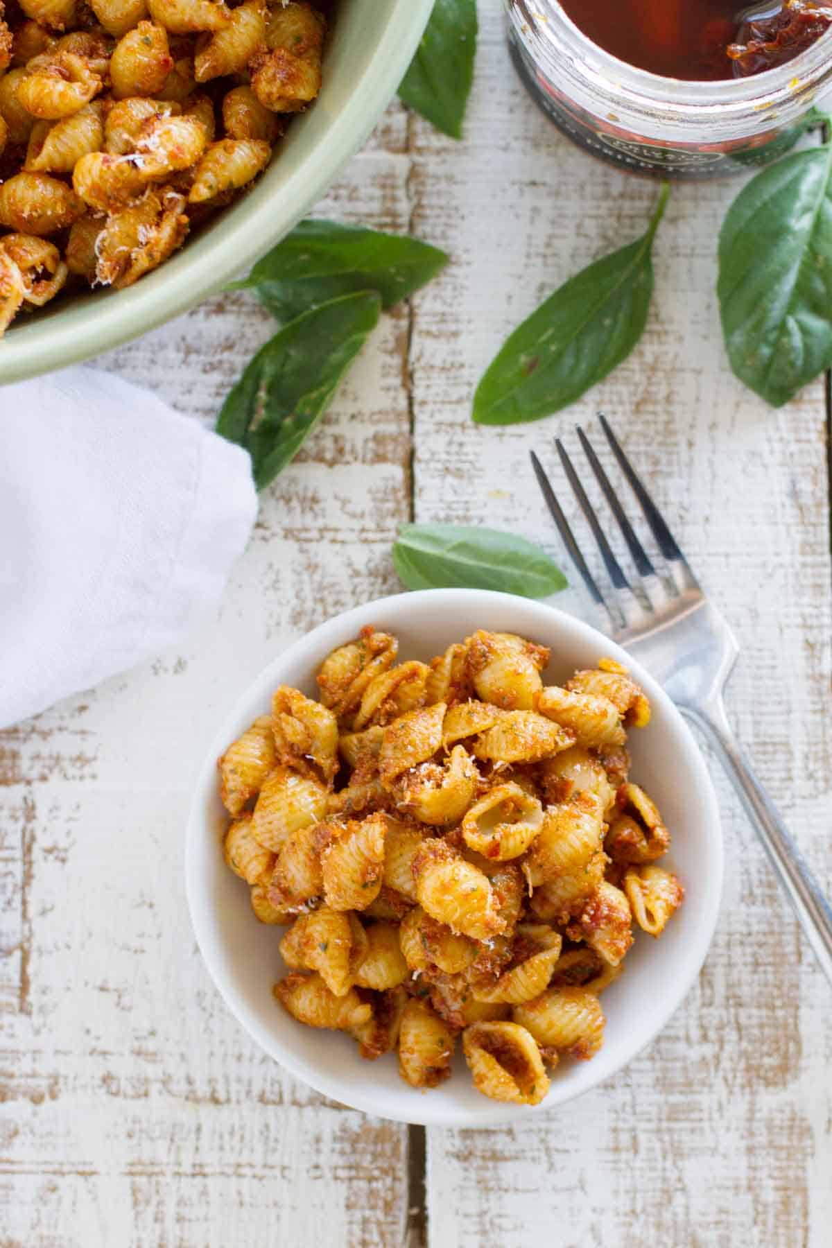 Serving of sun dried tomato pesto pasta salad in a small bowl.