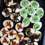 Halloween deviled eggs decorated three ways - green deviled eggs, spider deviled eggs, and deviled eyeballs.