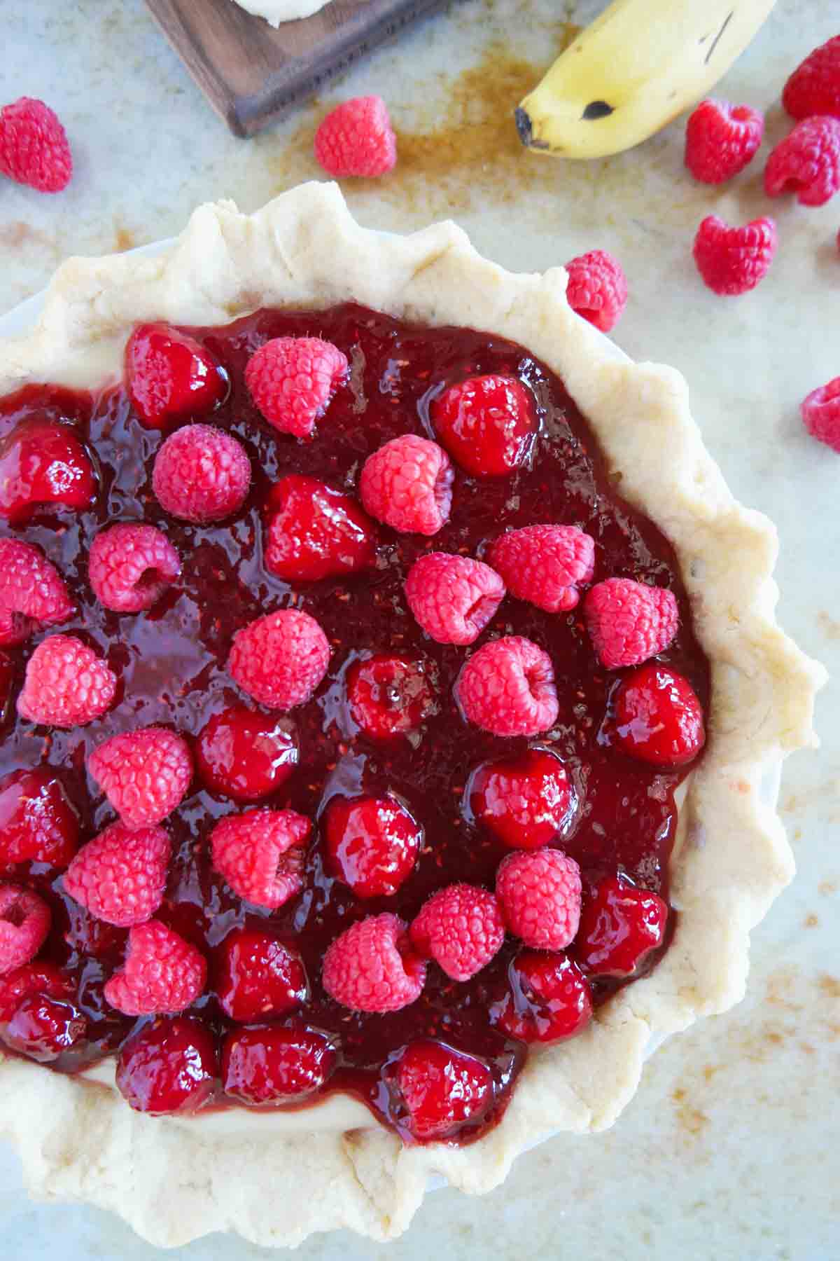 Full Raspberry Banana Pie topped with fresh raspberries.