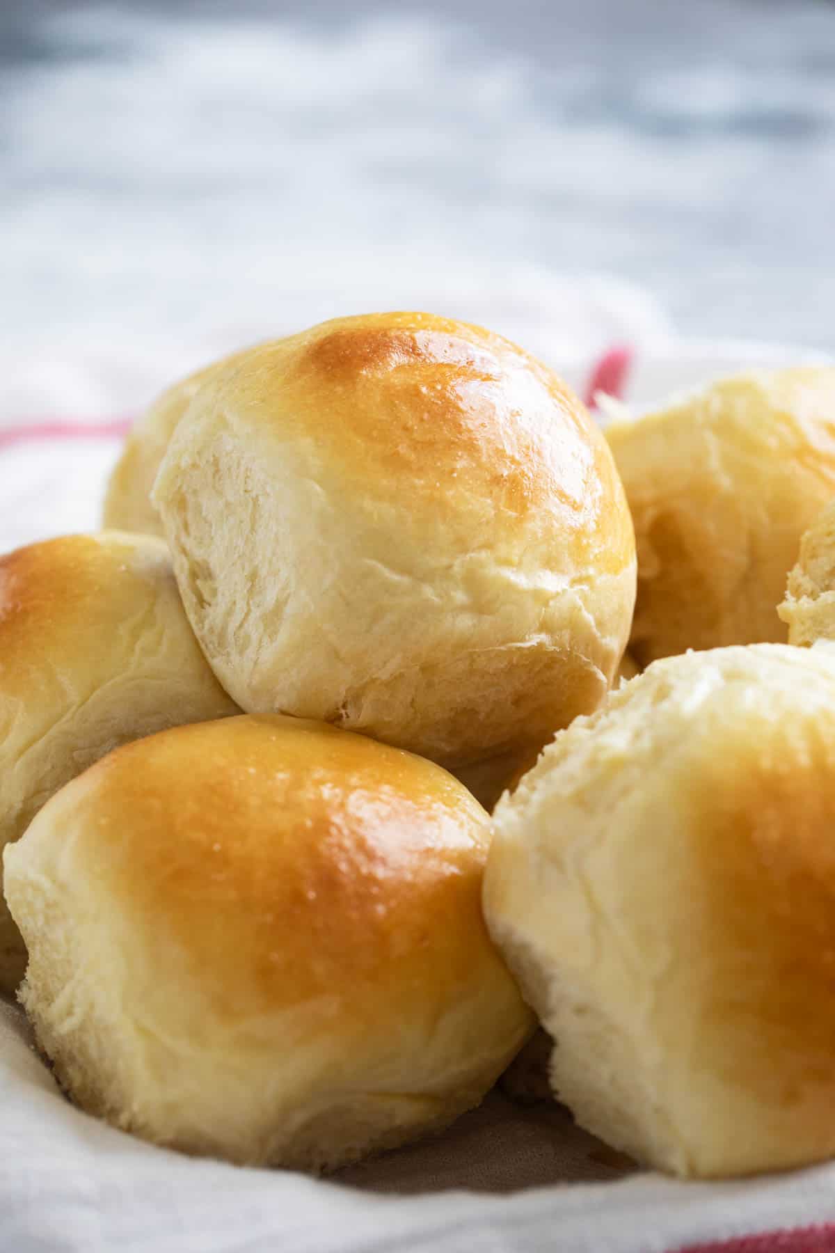 Brioche Rolls stacked in a bowl.