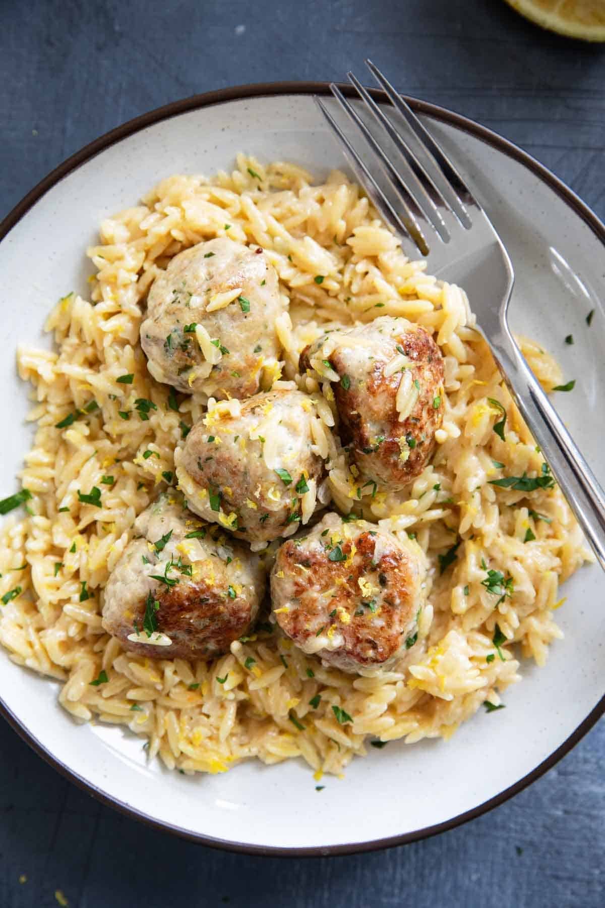 Plate with Chicken Meatballs over creamy lemon orzo.