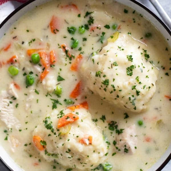 Bowl filled with chicken and dumplings, with two large dumplings.