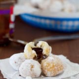 Chocolate Hazelnut Stuffed Donut Holes stacked on top of each other with one broken open.