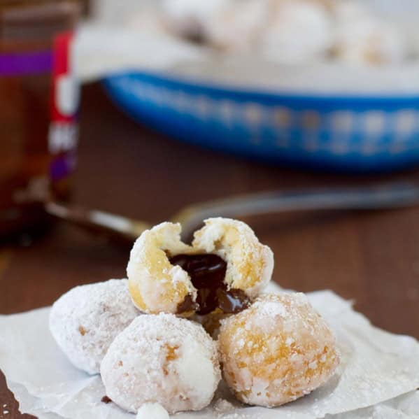 Chocolate Hazelnut Stuffed Donut Holes stacked on top of each other with one broken open.
