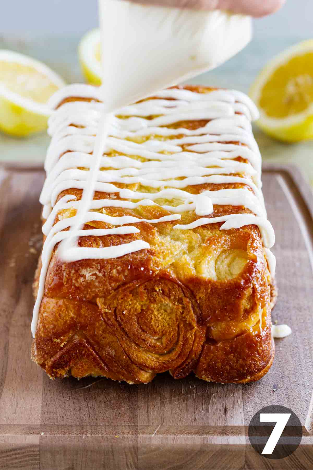 Putting icing on a loaf of lemon roll pull apart bread.