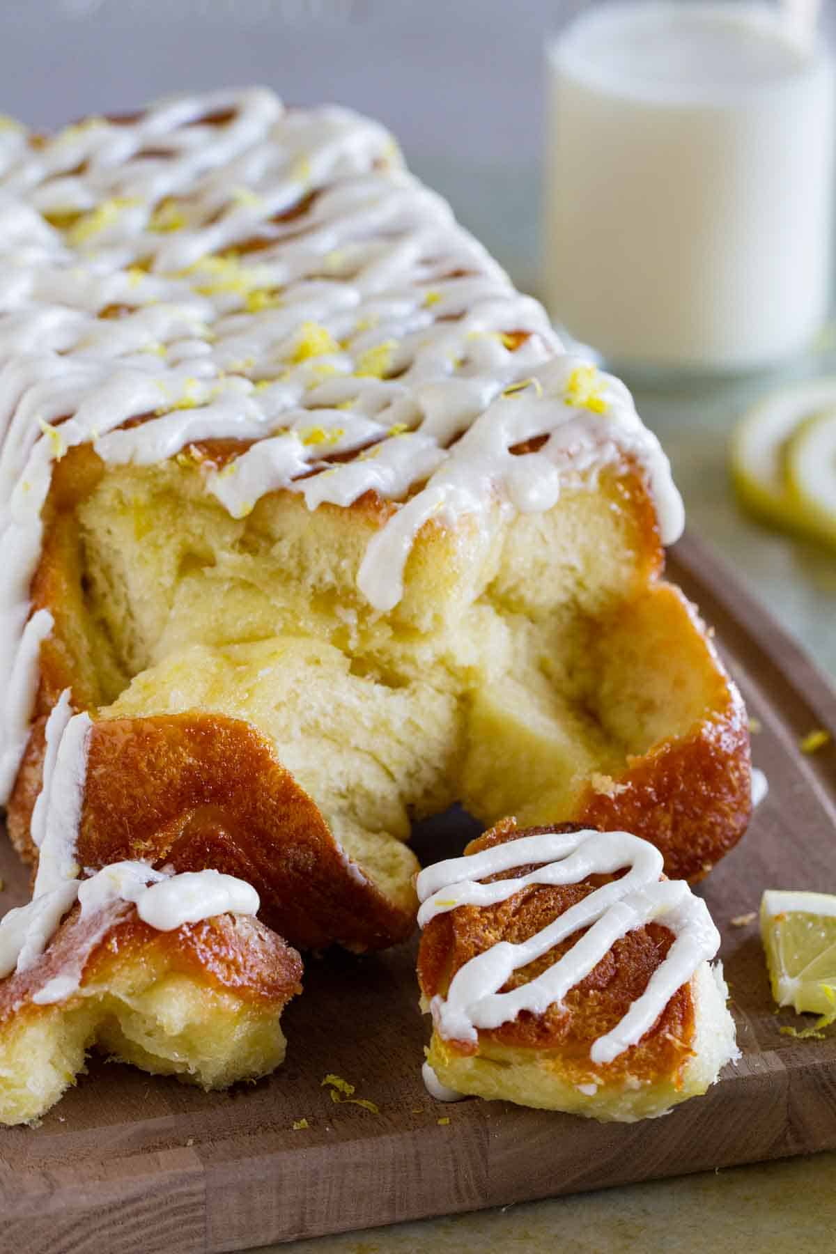 Loaf of lemon roll pull apart bread with pieces taken off.