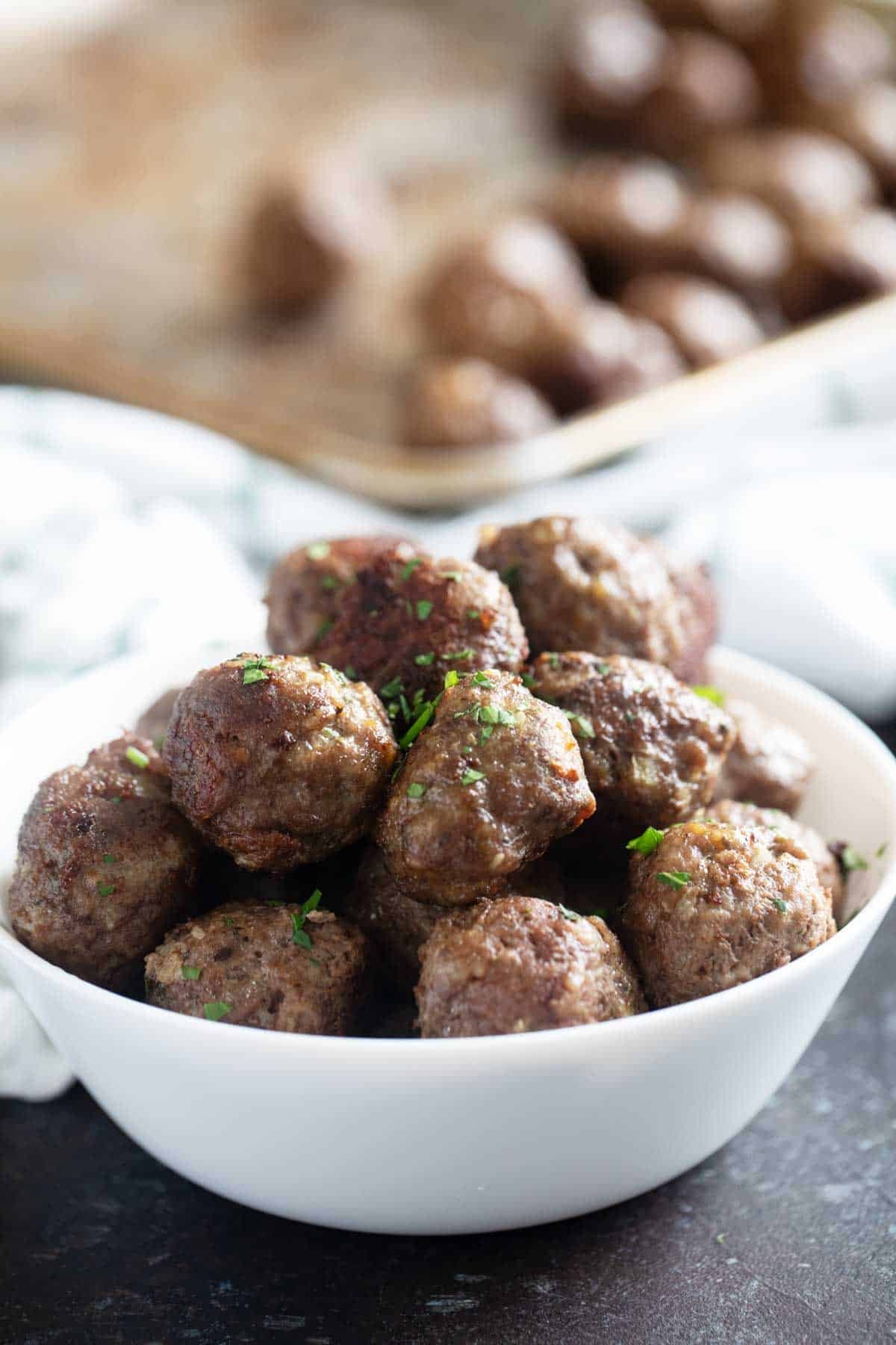 Bowl filled with baked meatballs.