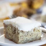 Slice of Banana Cake with Cream Cheese Frosting on a small plate.