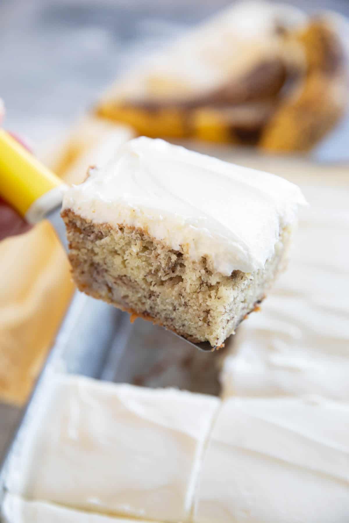 Removing a slice of banana cake from a cake pan.