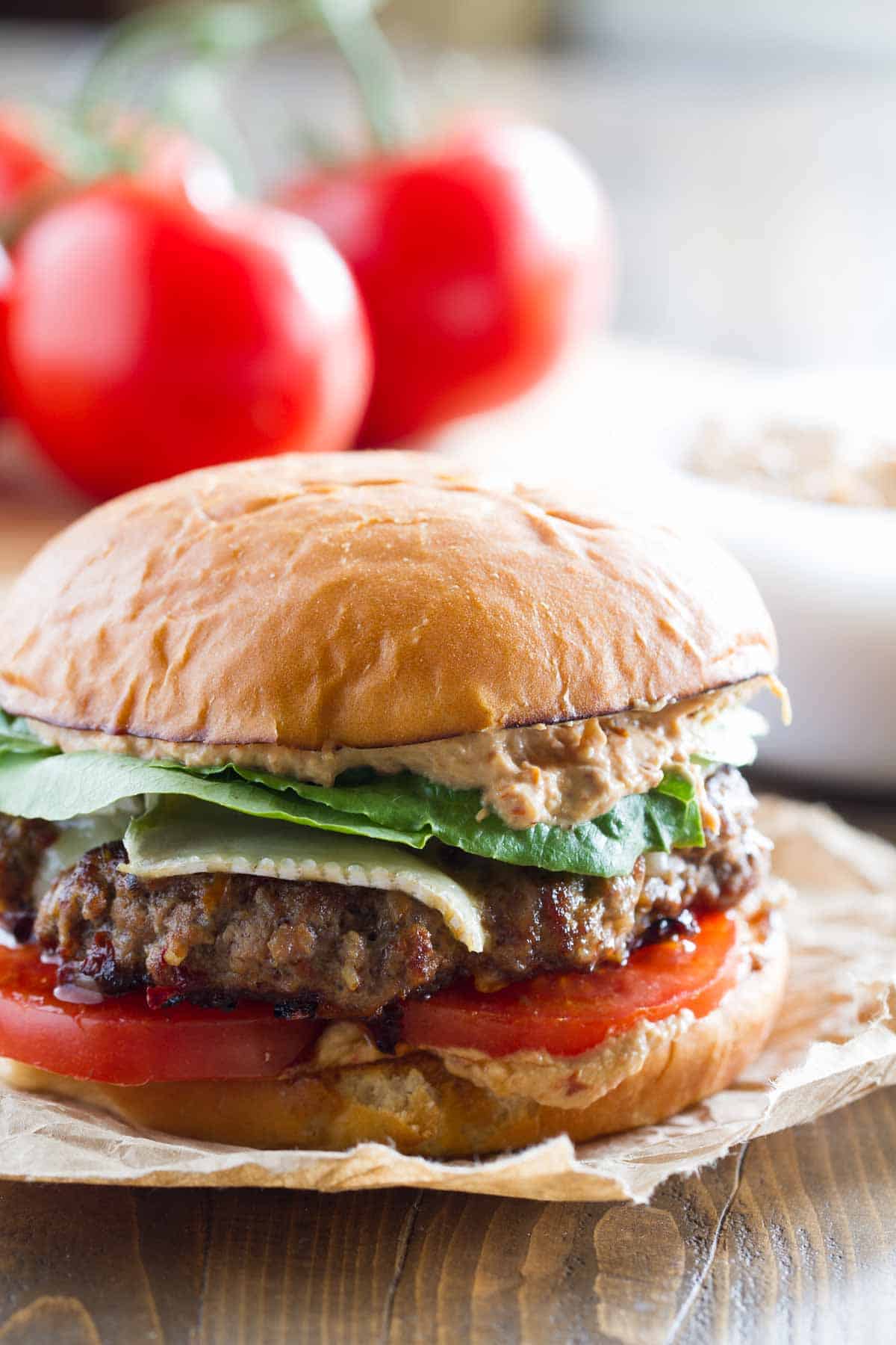 Brie Burger with Sun-Dried Tomato and Artichoke Spread with lettuce and tomatoes.