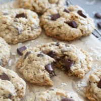 Chocolate Chunk Oatmeal Coconut Cookies on a cooling rack, with one cookie broken in half.