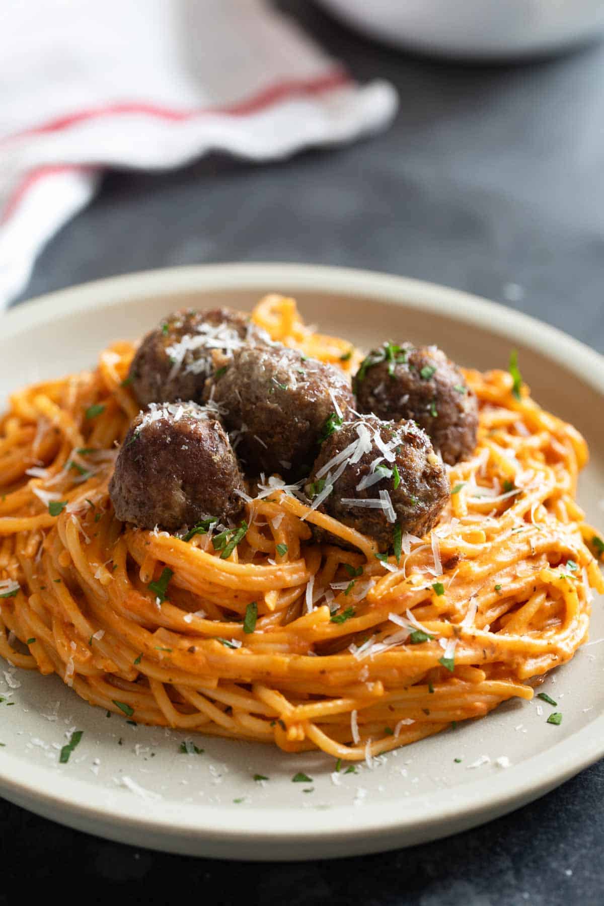 Plate filled with Creamy One Pot Spaghetti topped with meatballs.